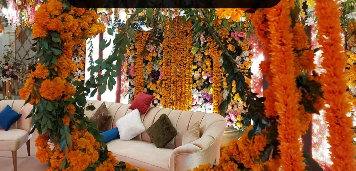 Mehndi lounge seating beneath marigold strings